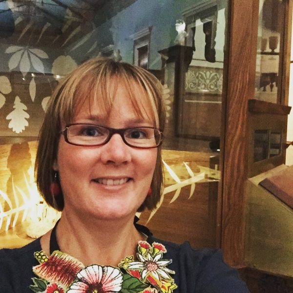 Head and shoulders shot of a woman posing in a museum