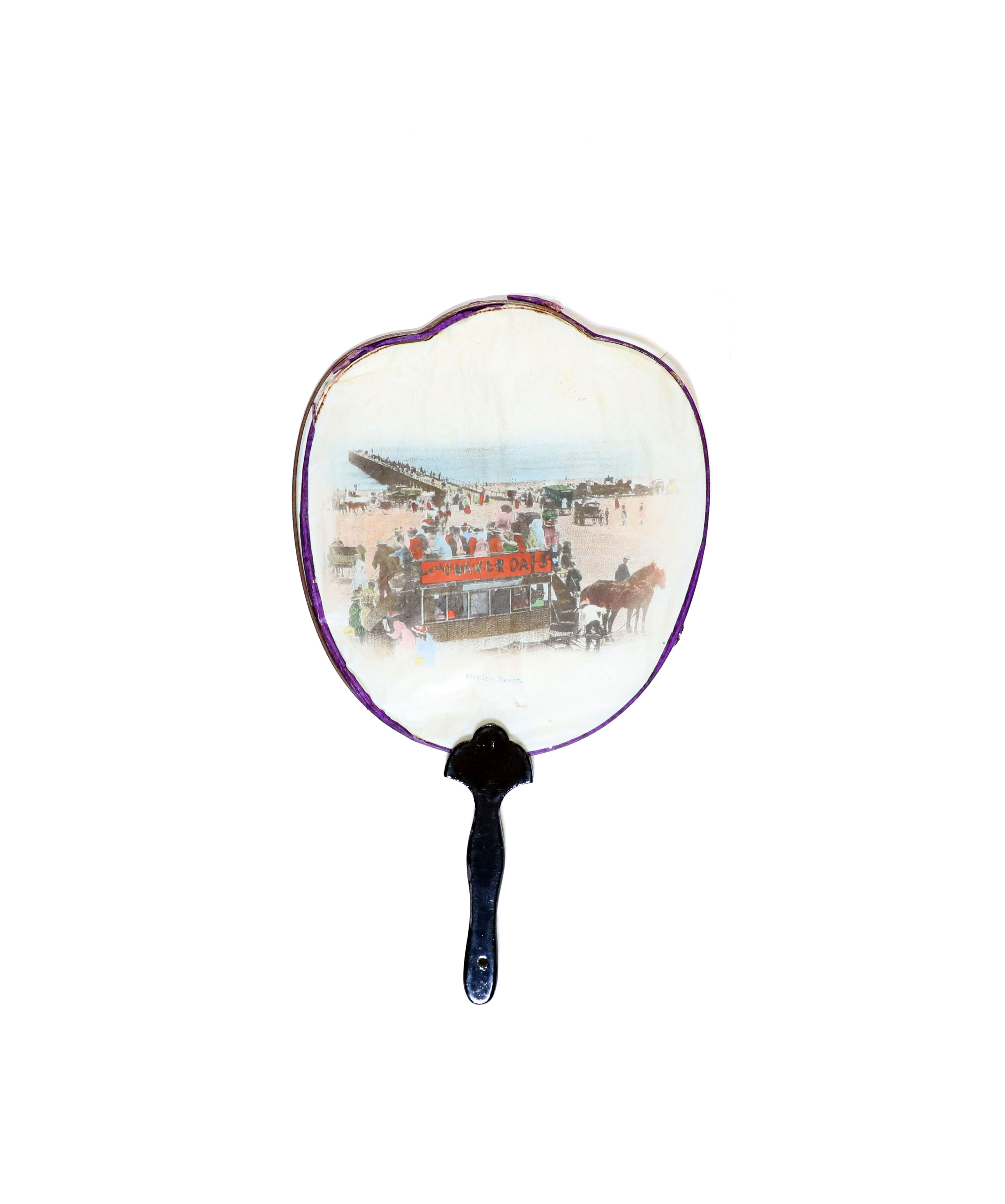 Japanese style paper fan printed with image of a beach with a jetty and tram. 