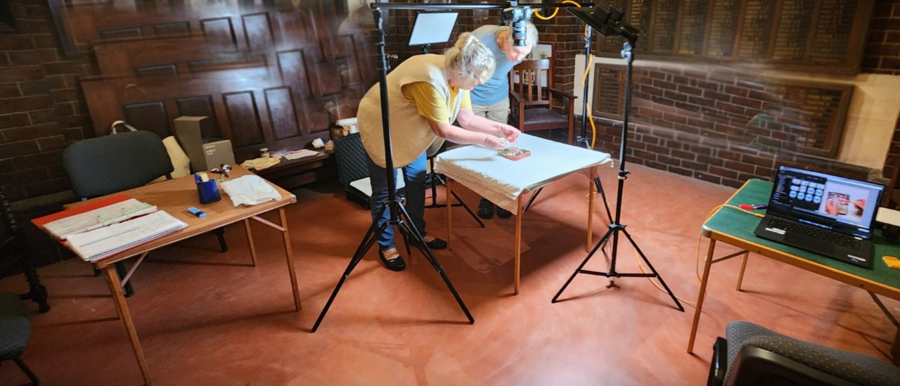 Woman and man bending over table and arranging objects on photo paper