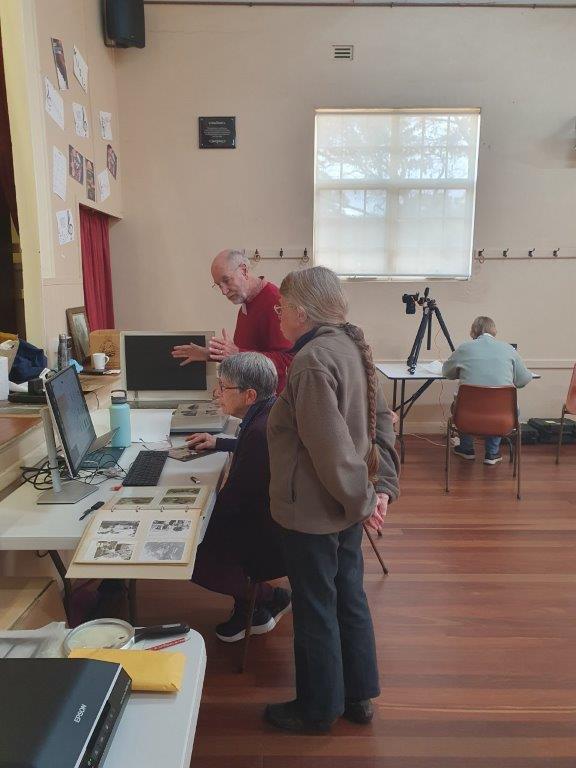 People looking at a person scanning photos